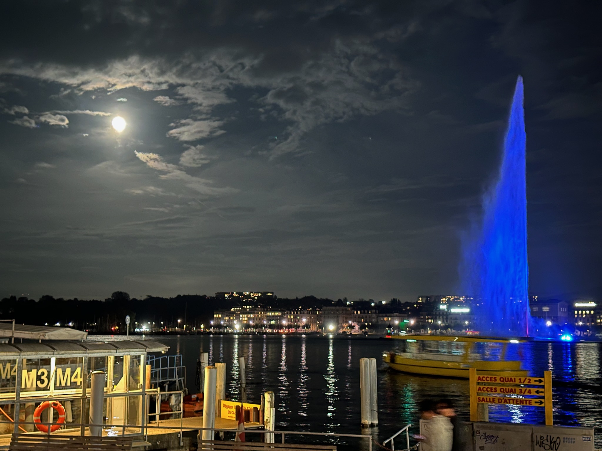 Moonlight shining on blue fountain in Lake Geneva